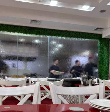 Pulling lagman noodles behind the glass waterfall.